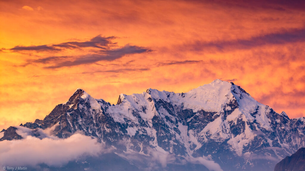 Mount Langtang Lirung, as viewed from the Laurebina Mountain Pass, under a bright orange sky