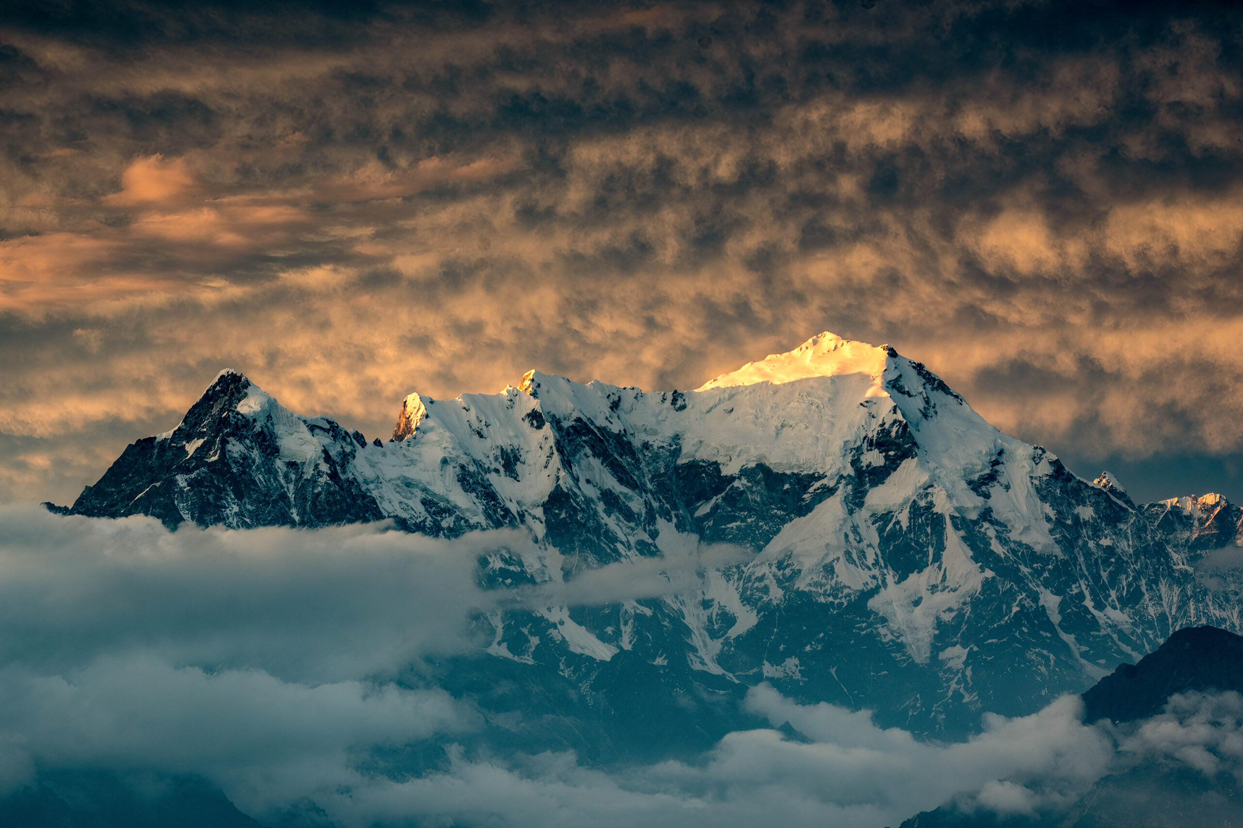 Mount Langtang Lirung, as viewed from the Laurebina Mountain Pass, under fluffy golden clouds