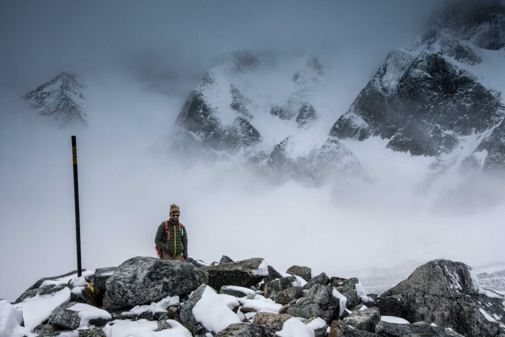 A man overlooking a misty Larkya La Pass