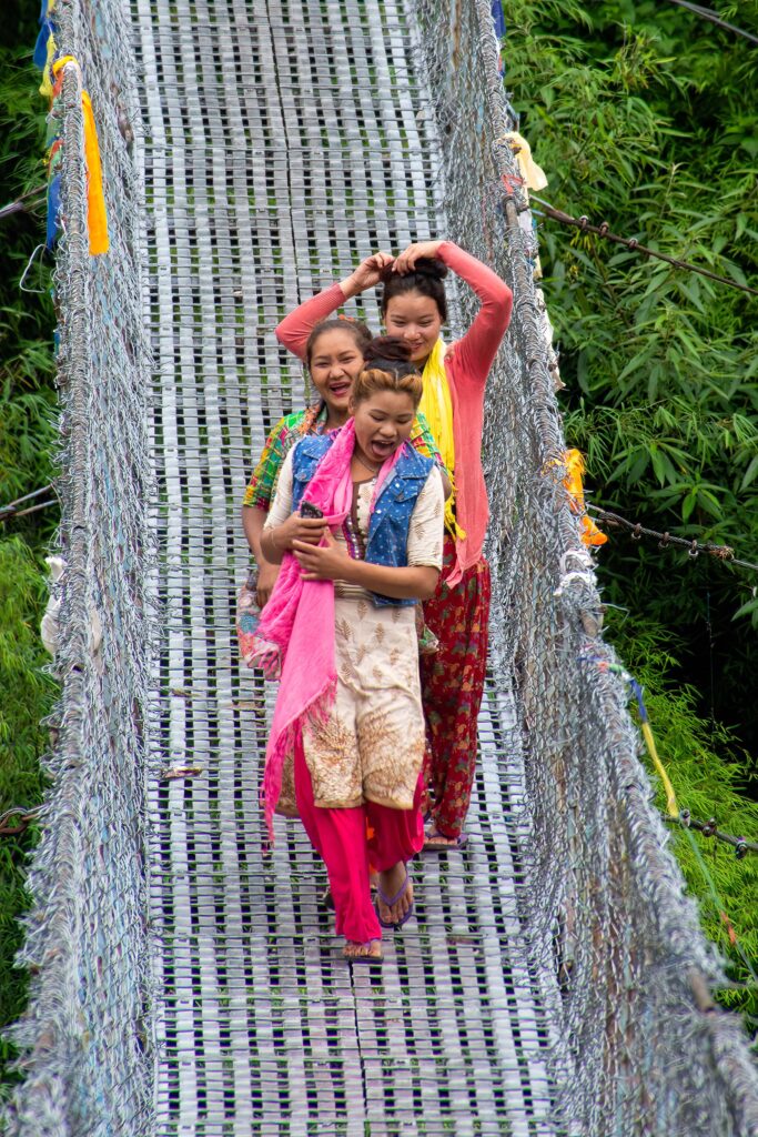 Three Nepalese women adorning brightly colored clothes