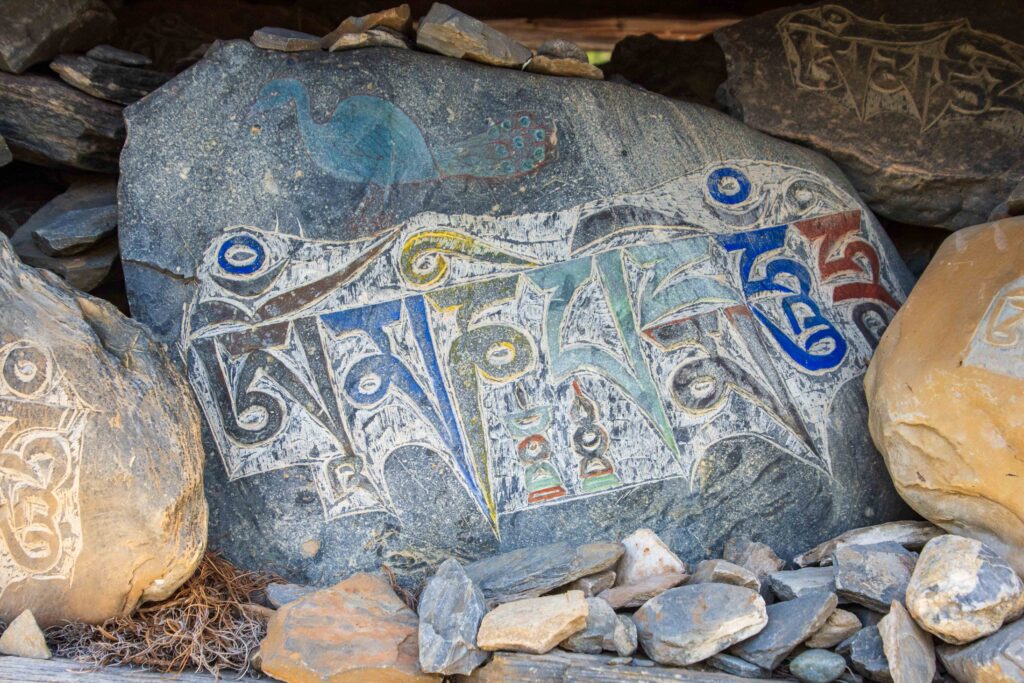 A carved and painted Mani Stone