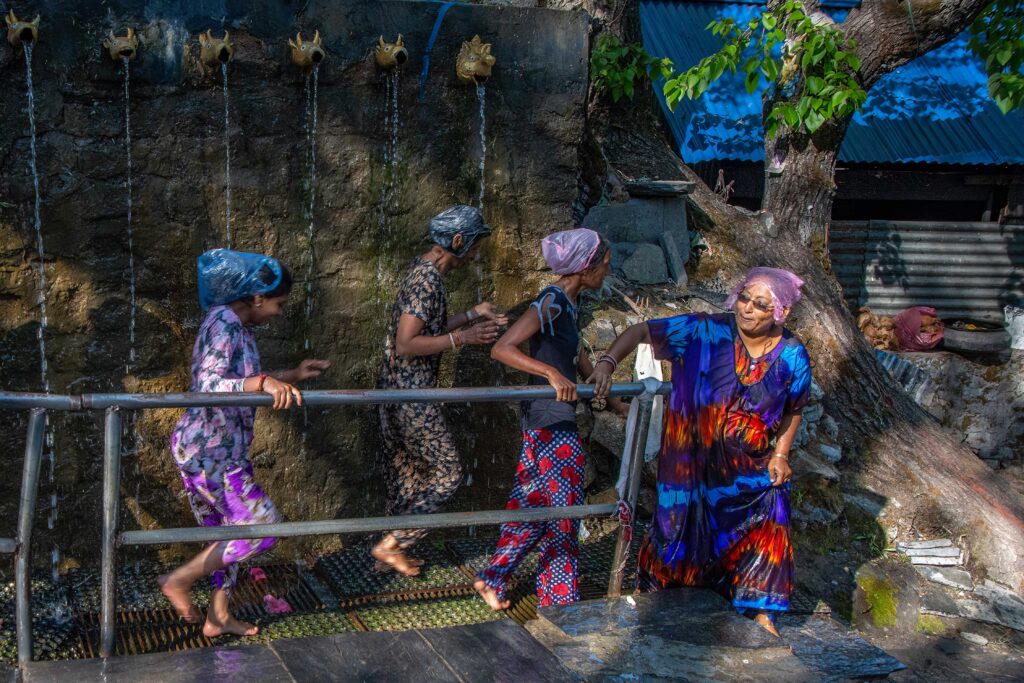 Multiple villagers running the Gauntlet of Cold Showers in the Shree Muktinath Temple, Annapurna Circuit