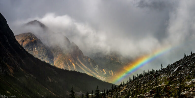 A bright rainbow and misty clouds above the vista from Angel Glacier hike