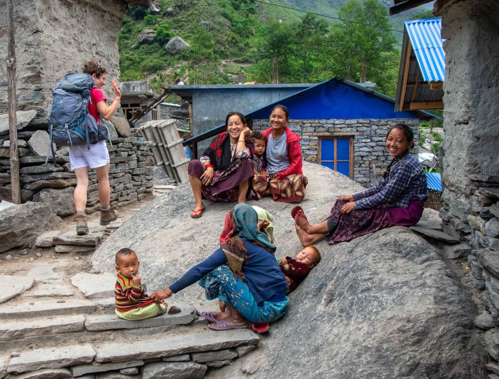 A group of Nepalese villagers smiling at passing travelers